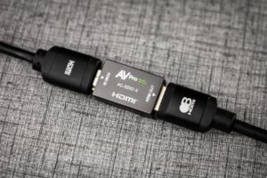 The AC-EDID-X inline between two HDMI cables on a gray surface